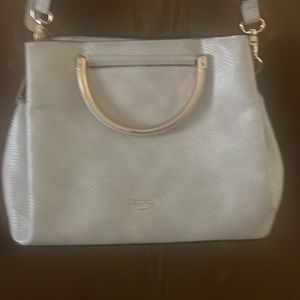 Cream colored purse. Has detachable shoulder strap. Three big pockets.